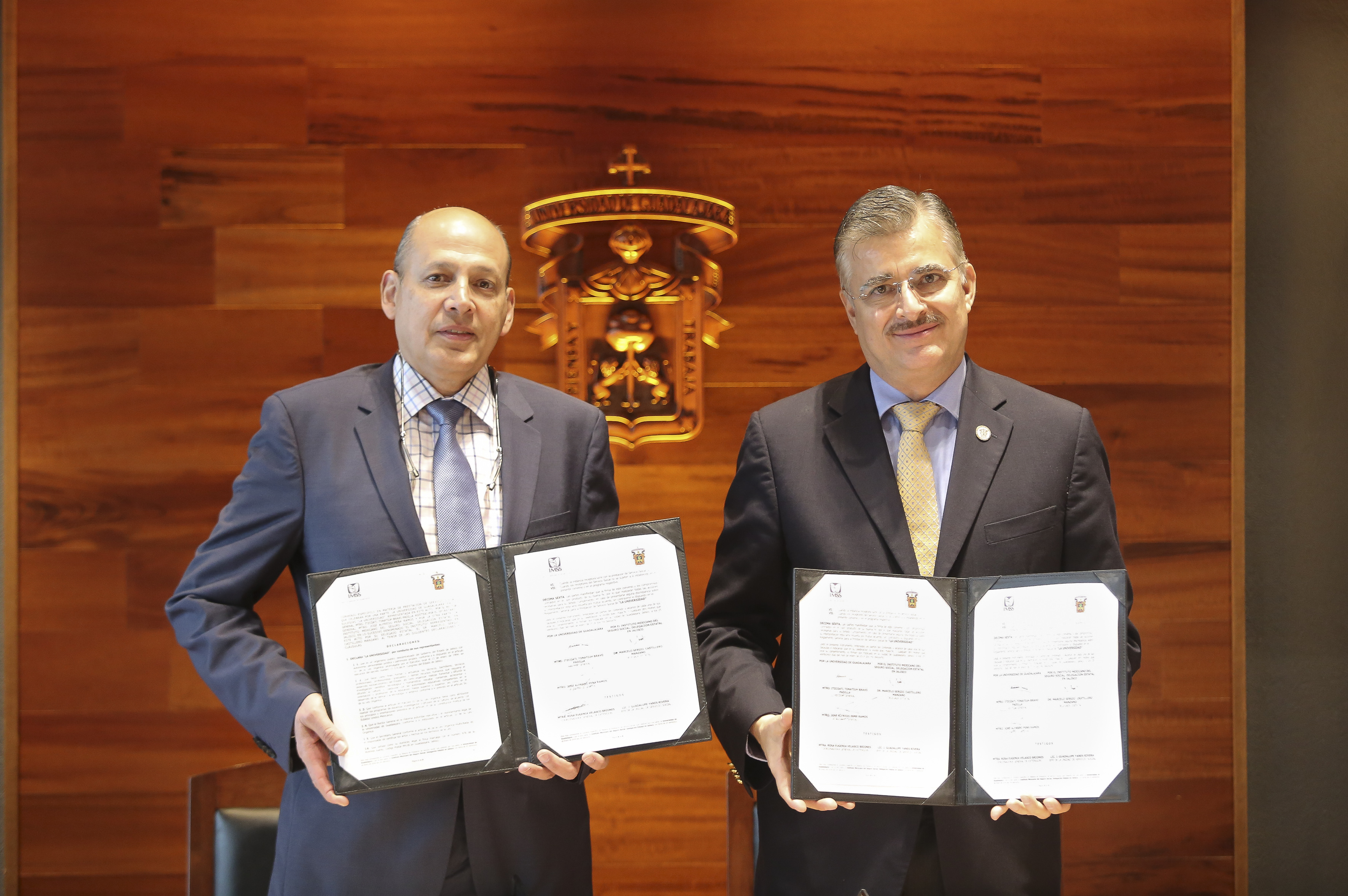 Delegado y Rector mostrando el convenio firmado