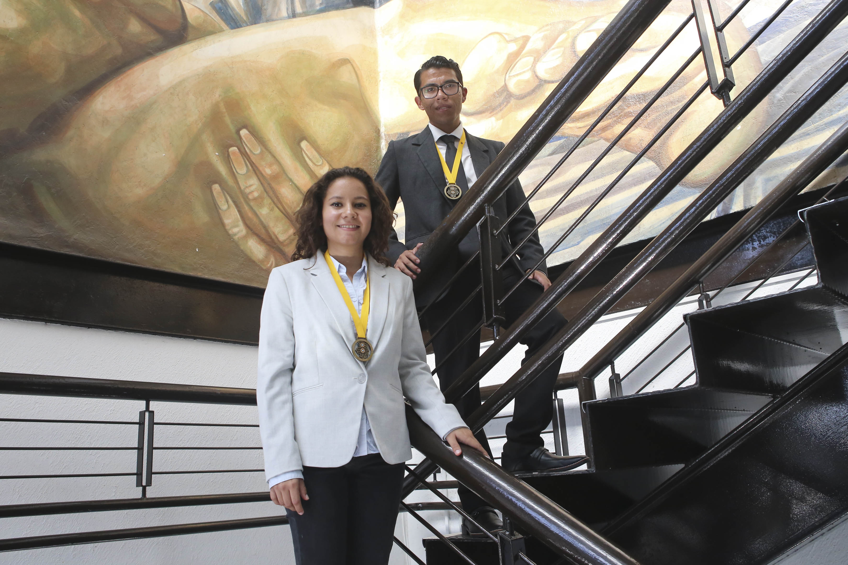 Alumnos ganadores con la medalla de oro bajando de las escaleras de Rectoría
