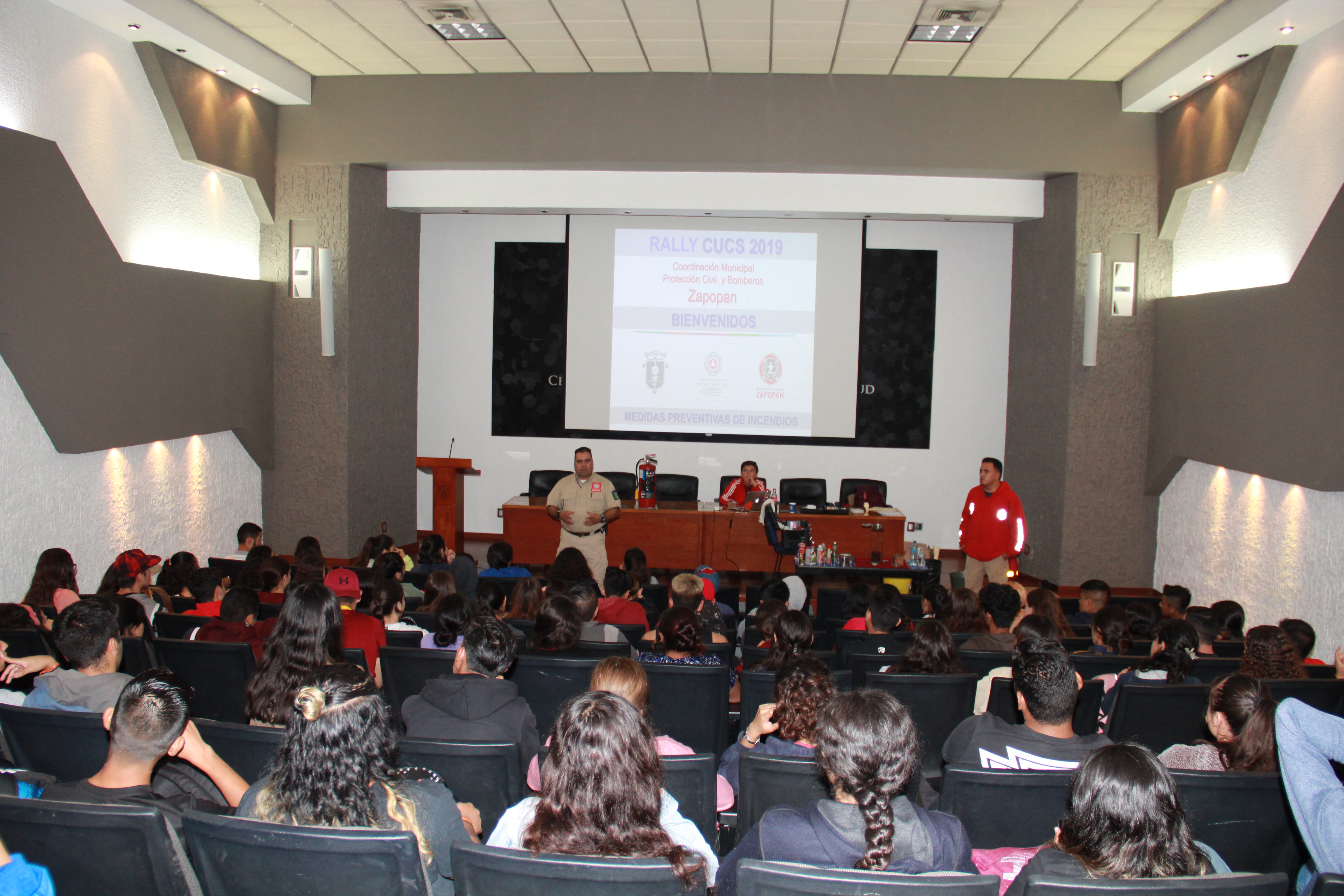 Auditorio lleno de alumnos recibiendo plática de protección civil