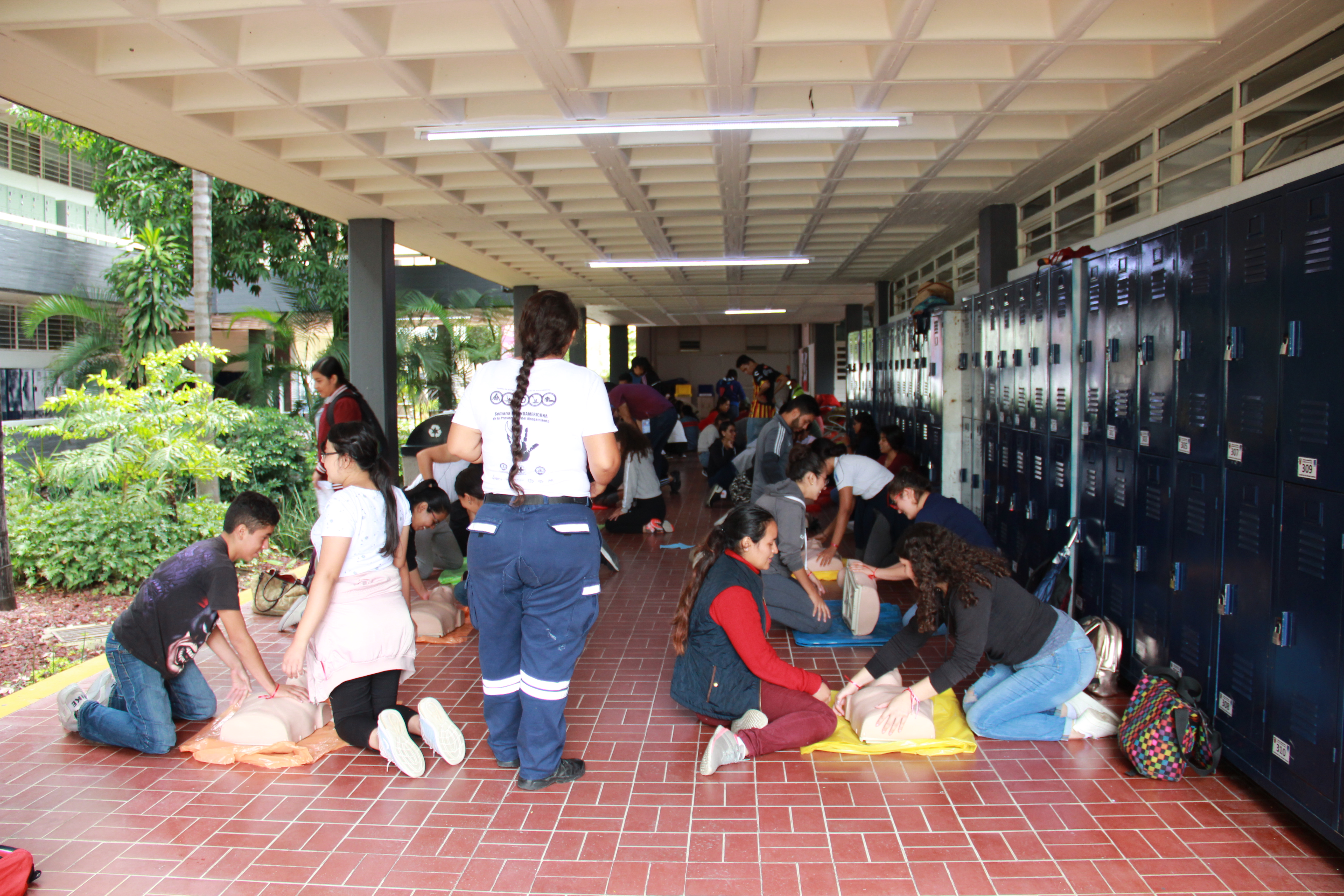 Voluntaria de protección civil instruyendo a alumnos en reanimación cardiopulmonar