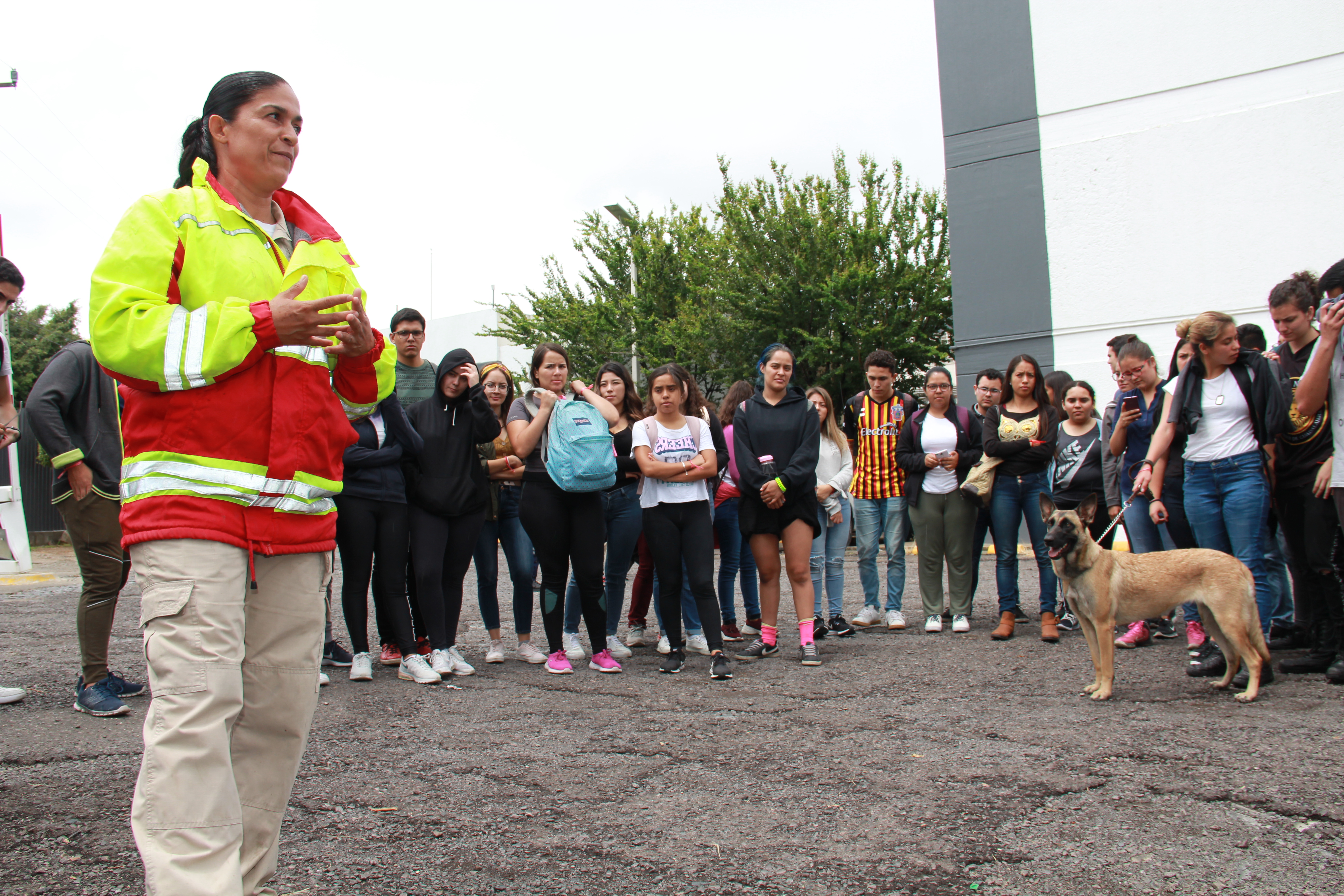 Elemento de protección civil ofreciendo plática de binomio canino a estudiantes