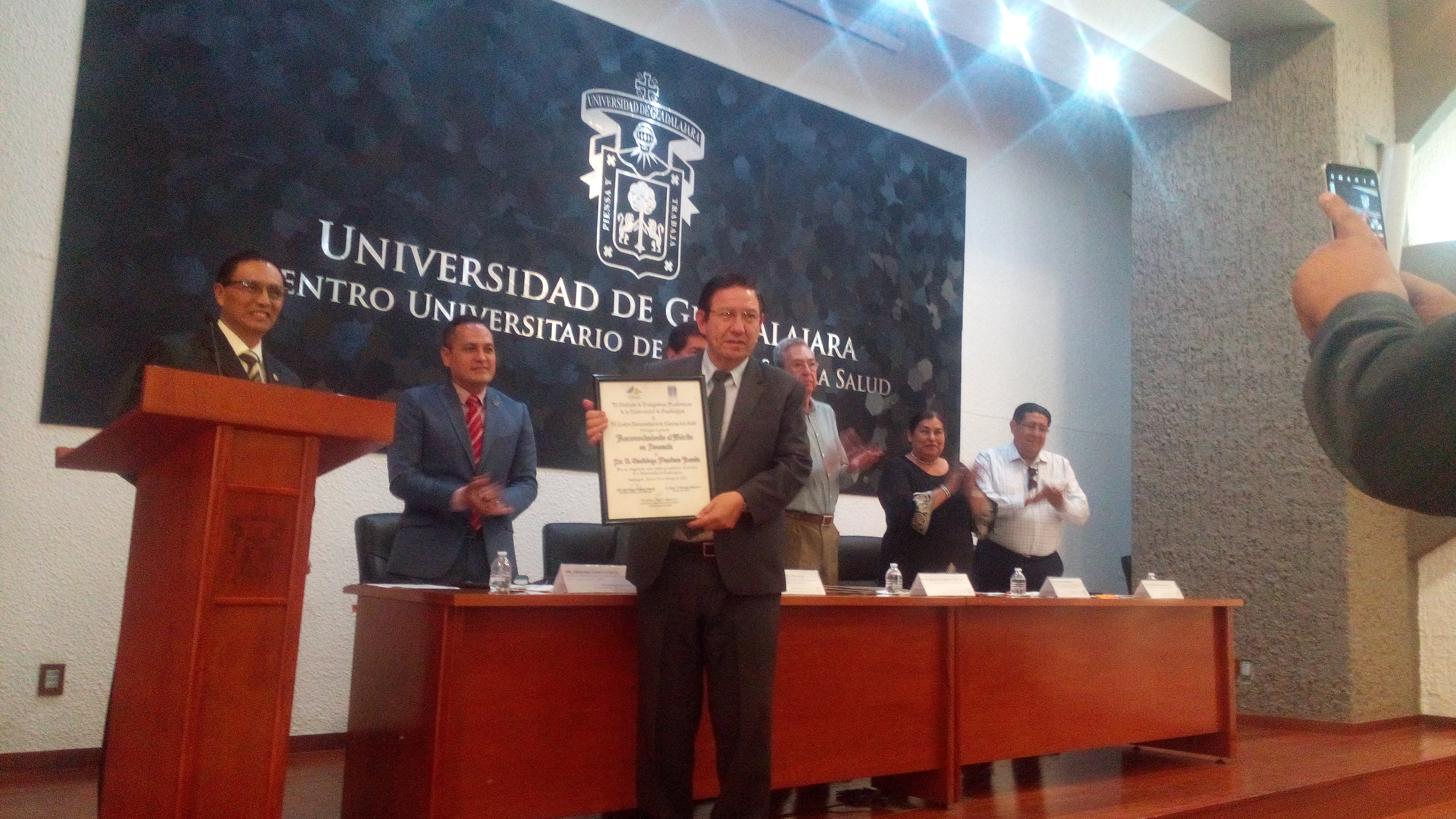 Dr. Panduro mostrando su Galardón a la Docencia