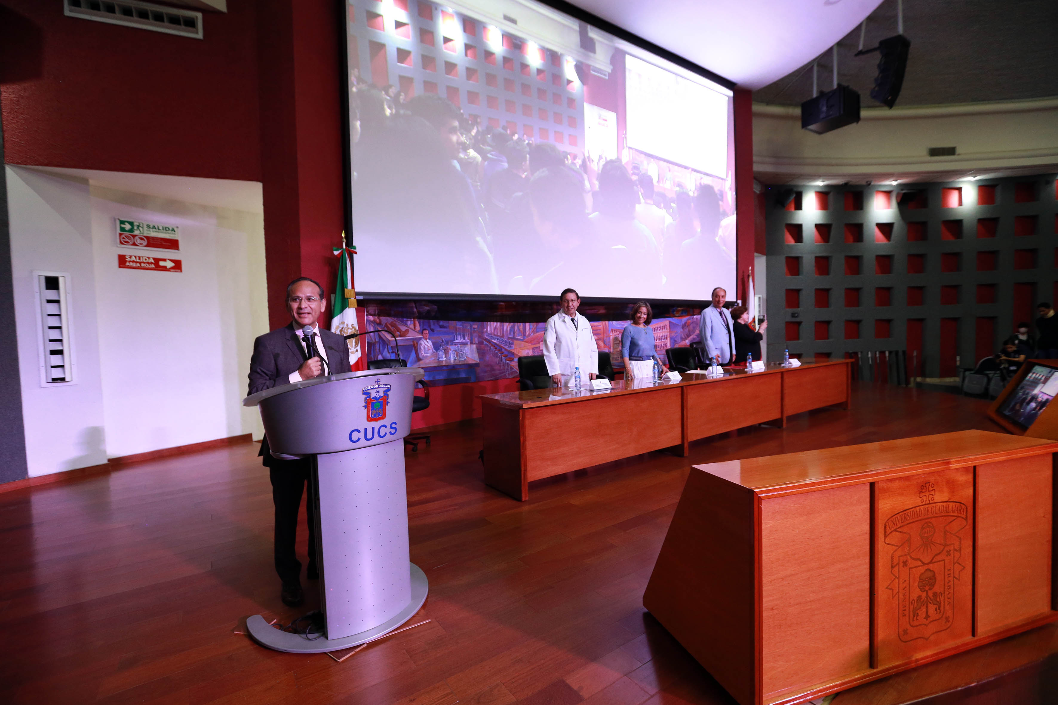 Miembros del presídium de pie durante la declaratoria inaugural del Coloquio