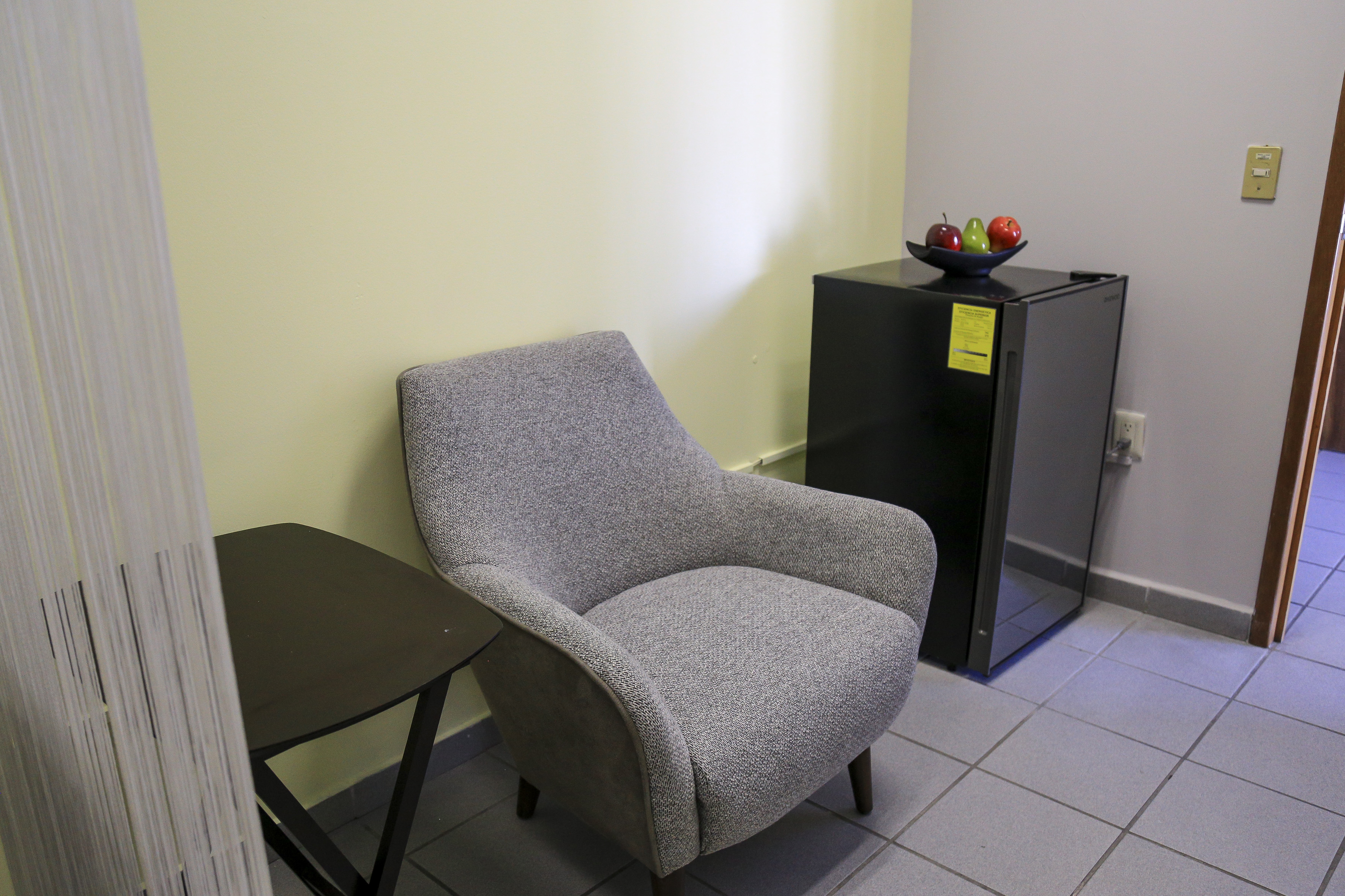 Sillón para lactar, al lado un frigobar para conservar la leche cuando esta es extraída