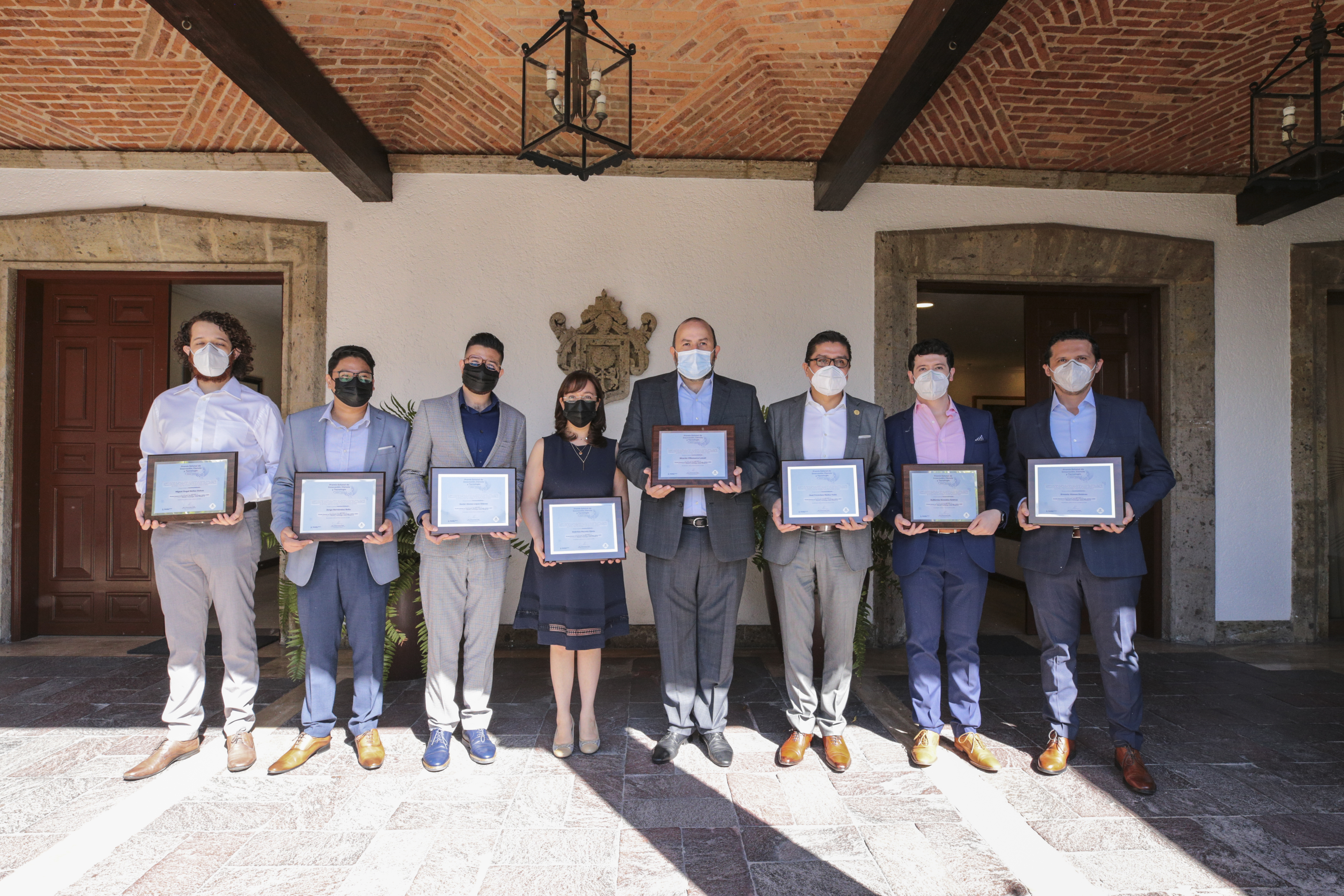 Integrantes de la Sala de Situación exhibiendo el reconocimiento en el patio de Casa Jalisco