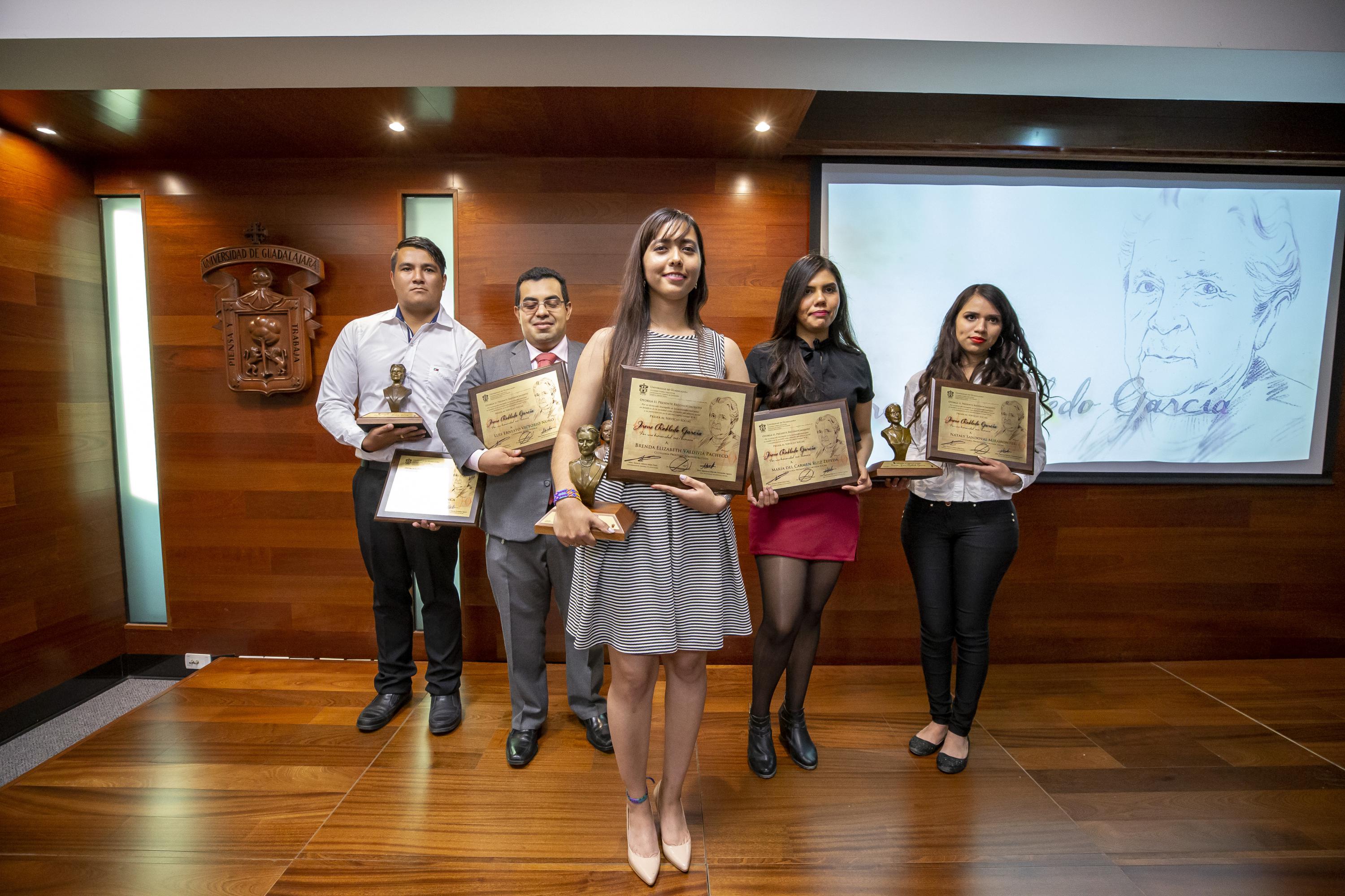 Foro grupal de los galardonados posando con sus reconocimientos y preseas