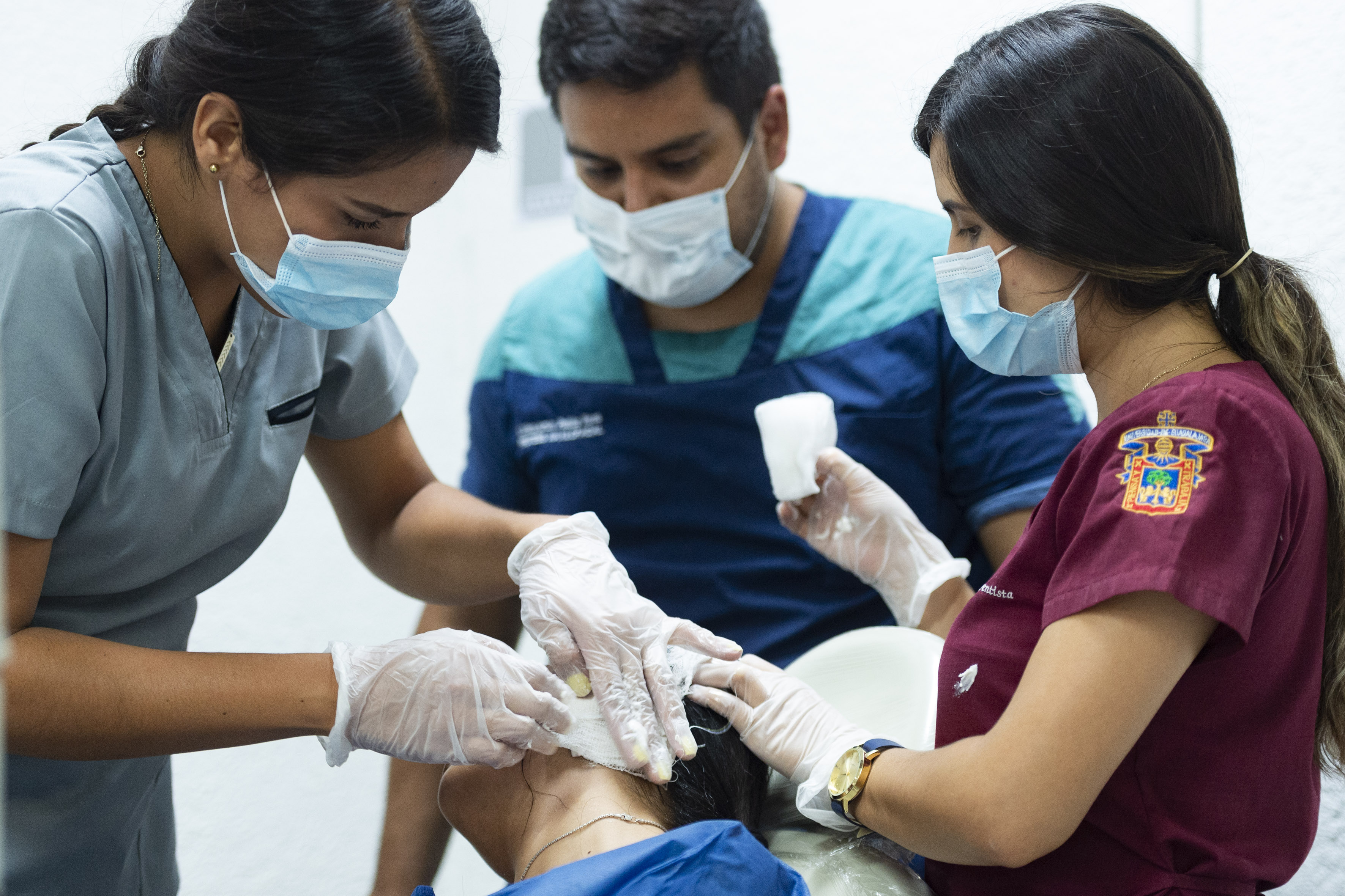 Estudiantes de especialidad tomando muestra de la oreja de una paciente 2