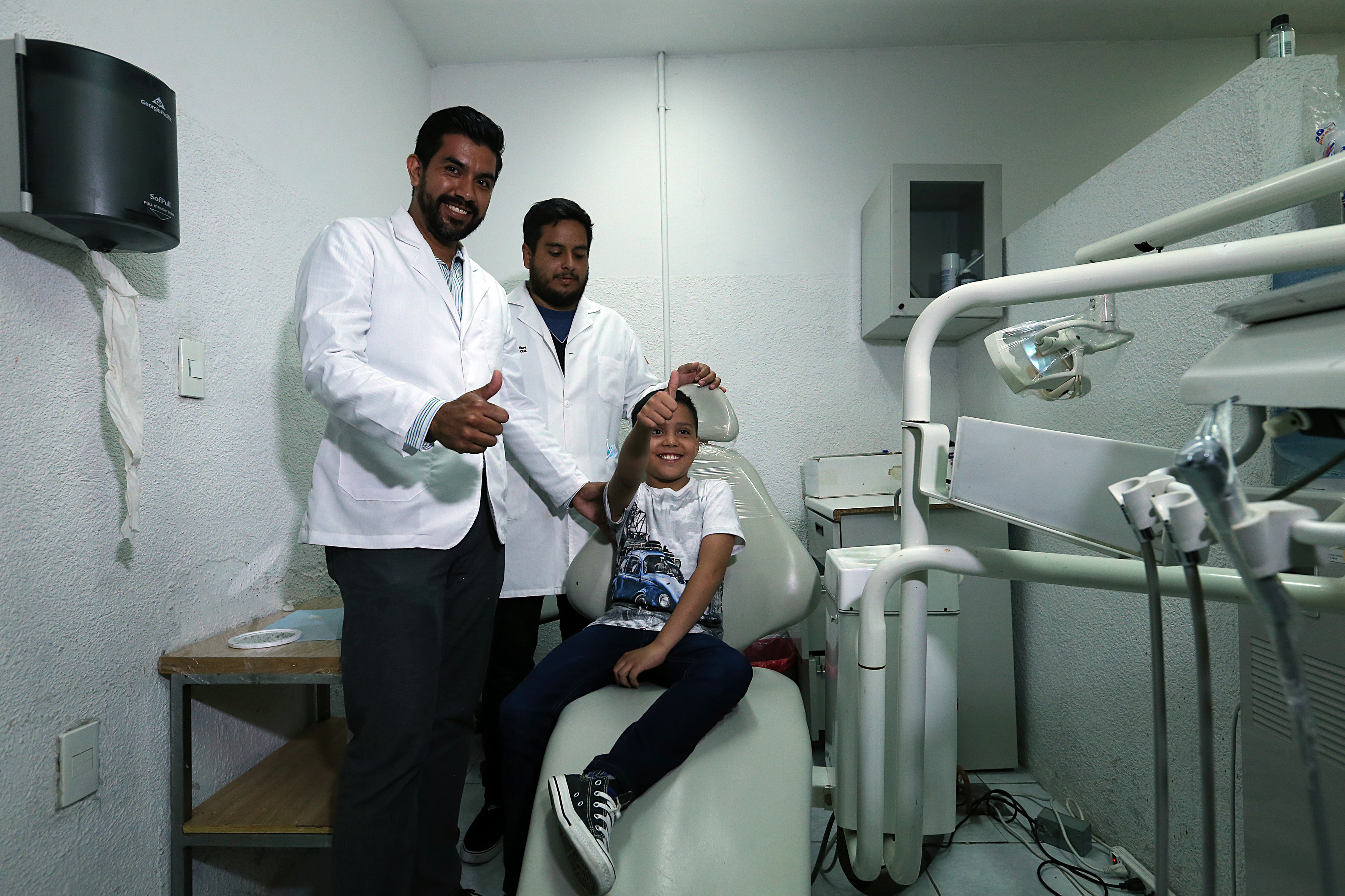 Médico, padre del niño y Joseph Gael posan para la foto después de la colocación de la prótesis