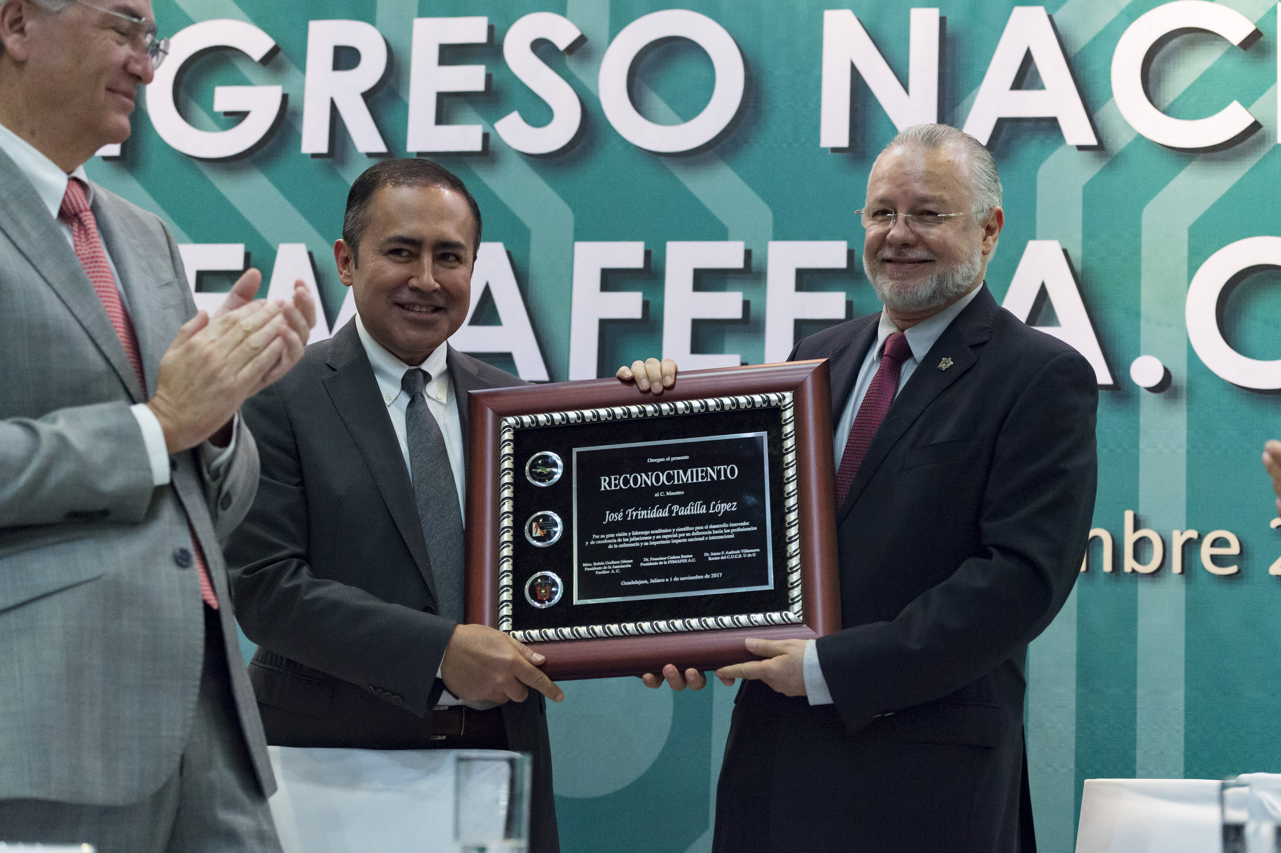 Rector del CUCS, Dr. Jaime Andrade y Lic. Trinidad Padilla exhibiendo el reconocimiento recibido por su liderazgo académico y científico