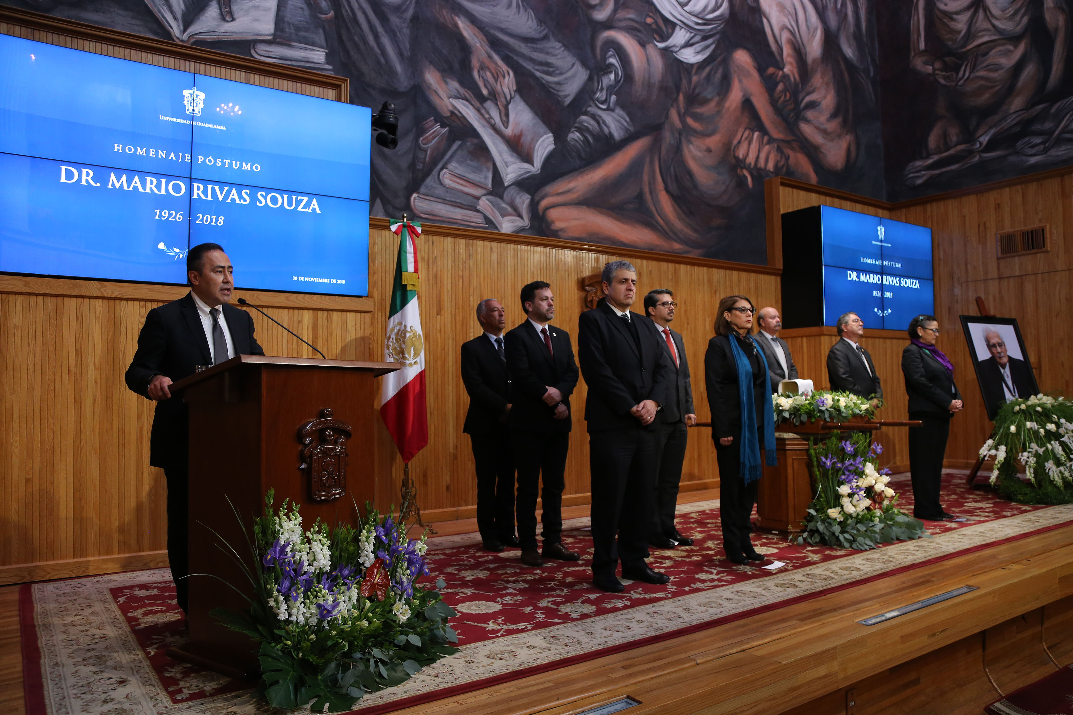 Rector del CUCS al micrófono en el podio del Paraninfo