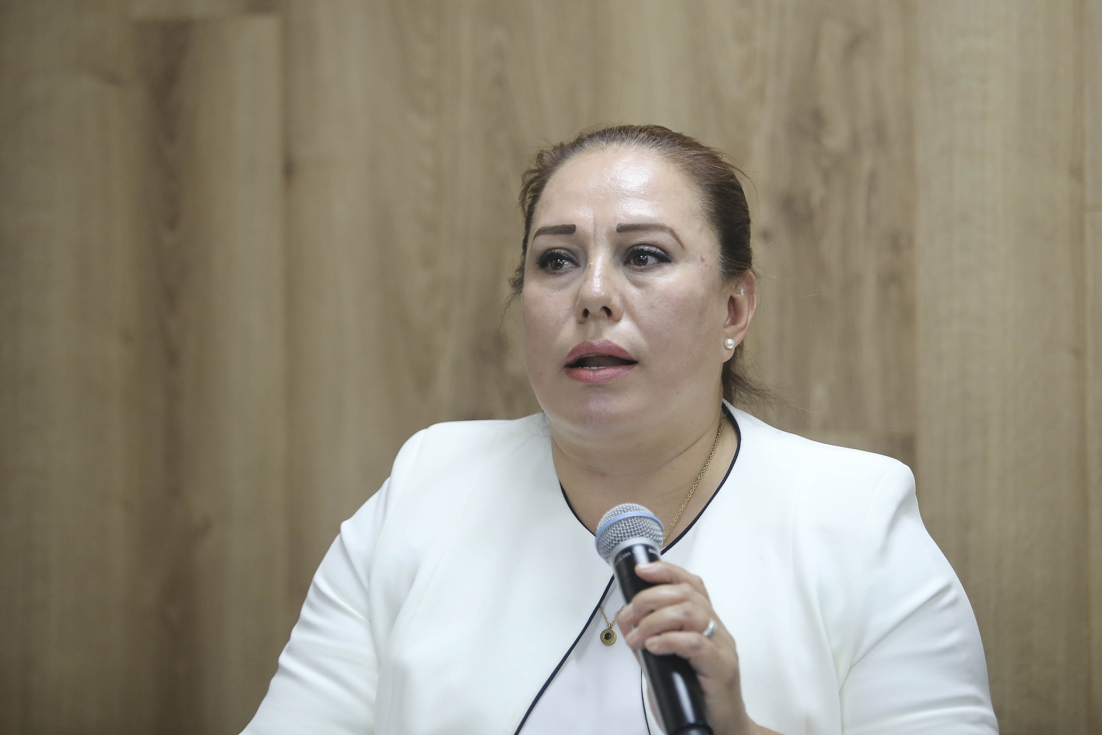 Mtra. Isabel Gómez al micrófono en rueda de prensa