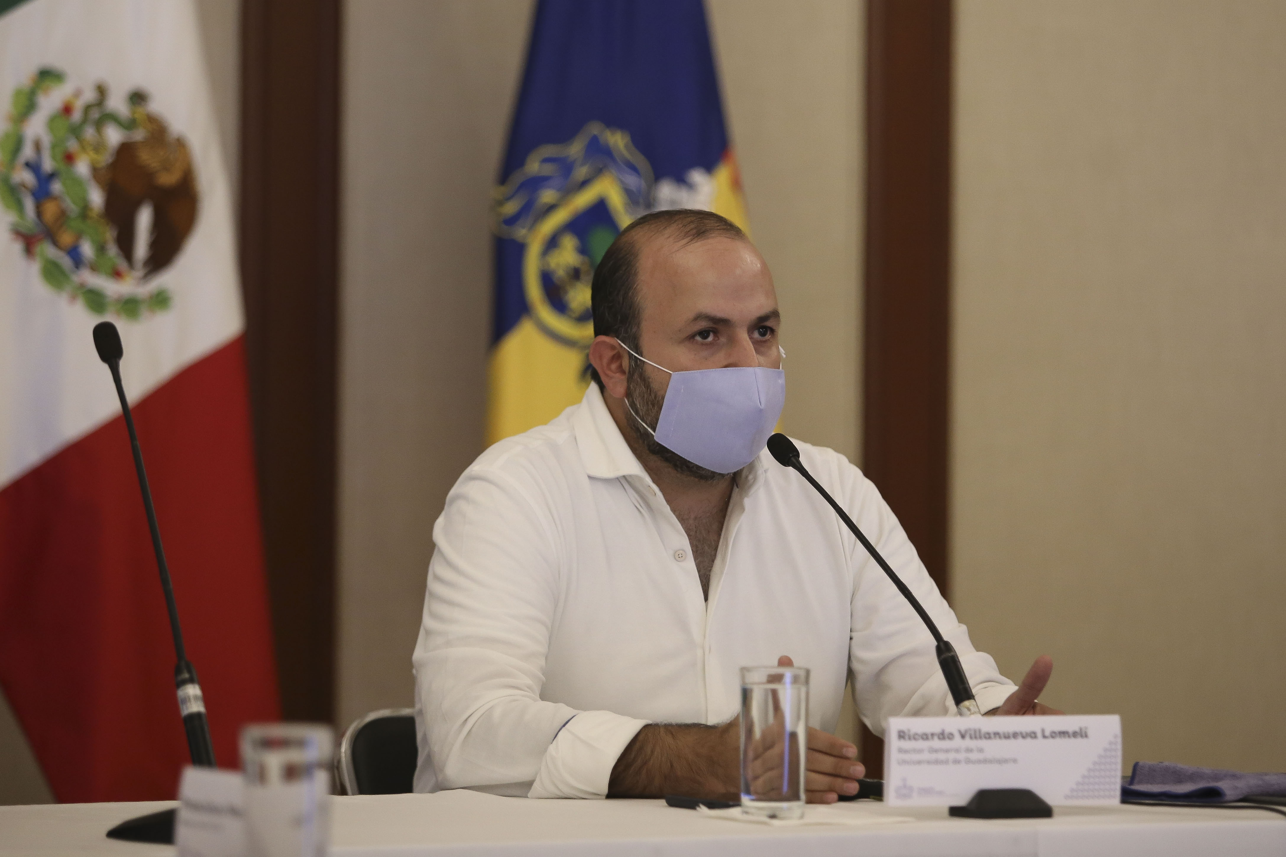 Rector General al micrófono con cubrebocas en rueda de prensa virtual en Casa Jalisco