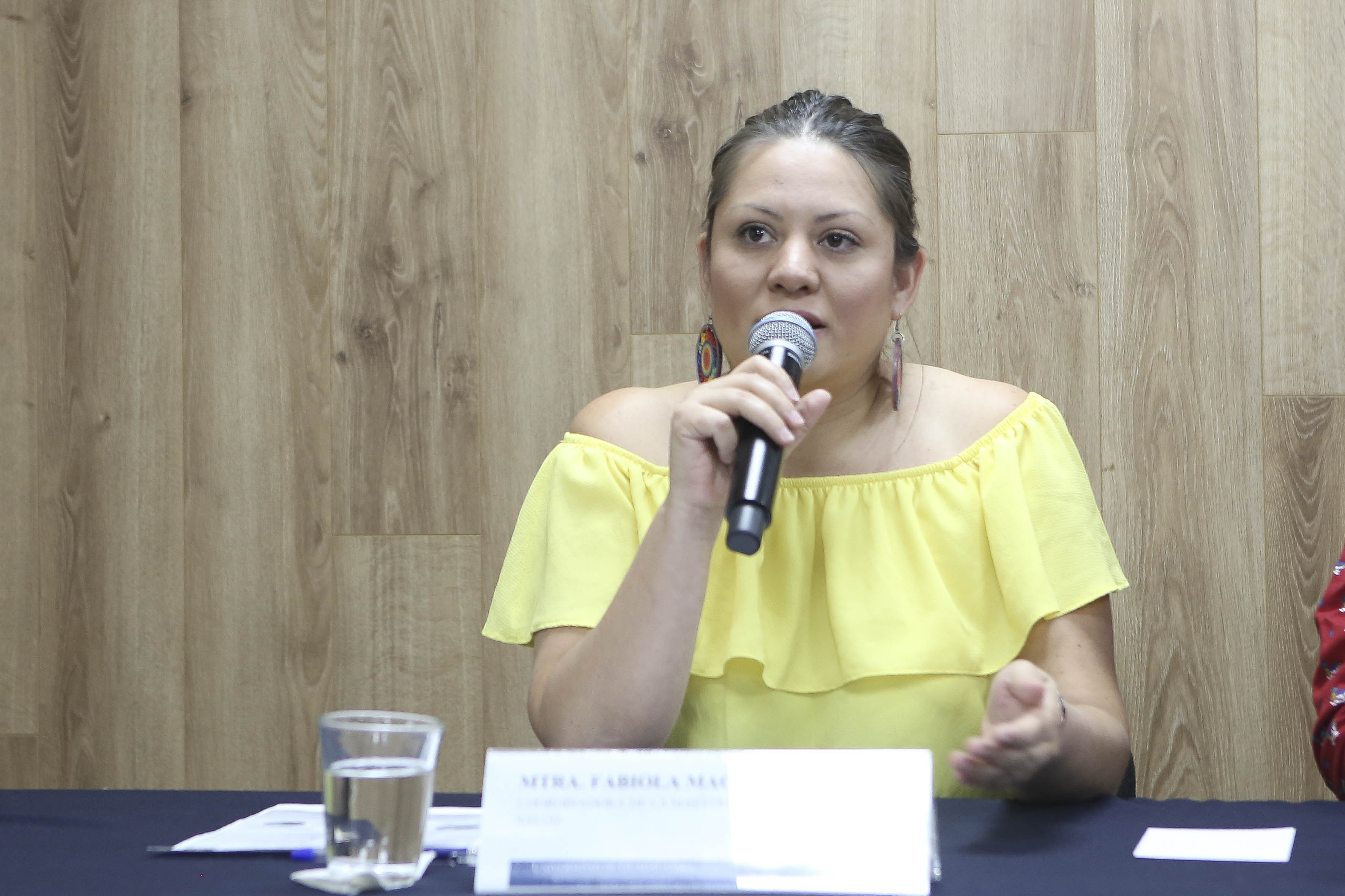 Mtra. Fabiola Macías al micrófono en rueda de prensa