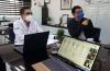 Rector analizando información en la pantalla de su oficina junto con el coordinador de Planeación