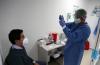 Personal de salud prepara el isopo frente al paciente