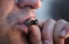 Rosrro de un varón fumando un cigarrillo de marihuana