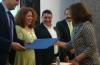 Secretario Académico entregando reconocimiento a una profesora