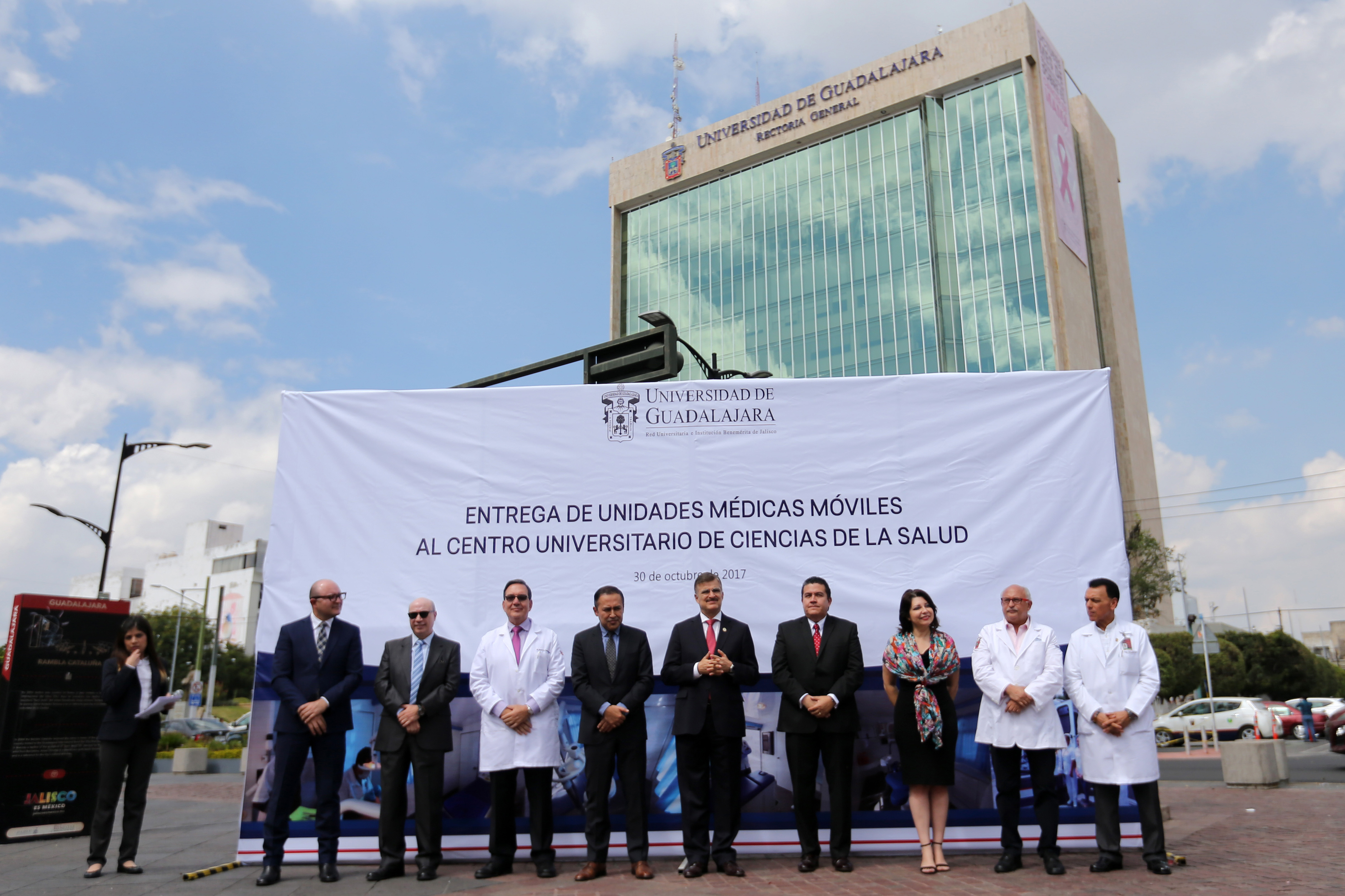Miembros del presídium del evento de entrega de Unidades Móviles de Salud. De fondo el edificio de Rectoría General